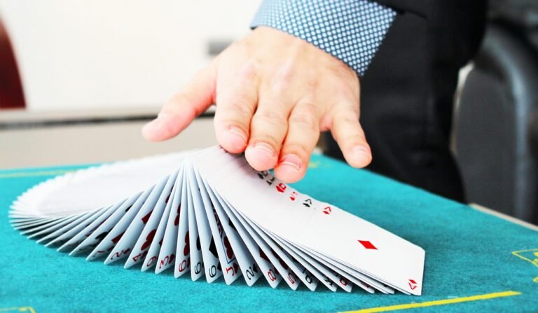 A hand fanning a pack of playing cards as if they are dominos.