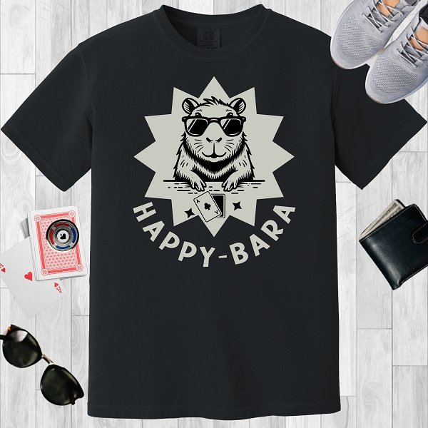Black colored unisex crewneck poker-themed T-shirt. Design features the text 'Happy-bara'. An image of a sunglass-wearing capybara with playing cards on a starburst background.