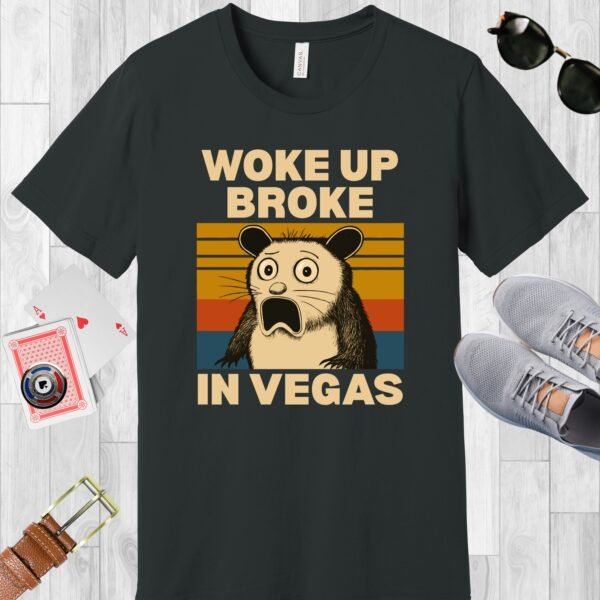 Dark Grey colored Bella+Canvas crewneck poker-themed T-shirt. Design features a shocked possum and the text 'Woke up broke in Vegas'.