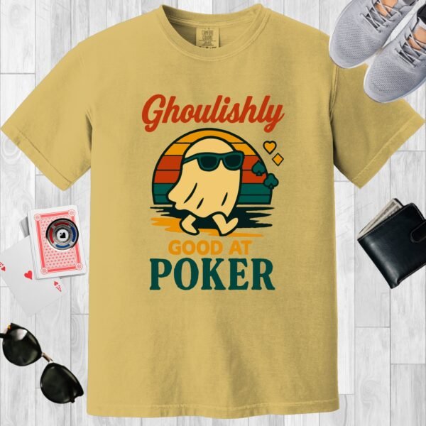 Mustard colored Comfort Colors crewneck poker-themed T-shirt. Design features the multi-colored text 'Ghoulishly good at poker'. There's an image of a sunglass-wearing ghost in front of a vintage sunset.