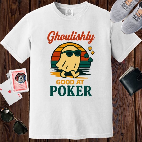 White colored Comfort Colors crewneck poker-themed T-shirt. Design features the multi-colored text 'Ghoulishly good at poker'. There's an image of a sunglass-wearing ghost in front of a vintage sunset.