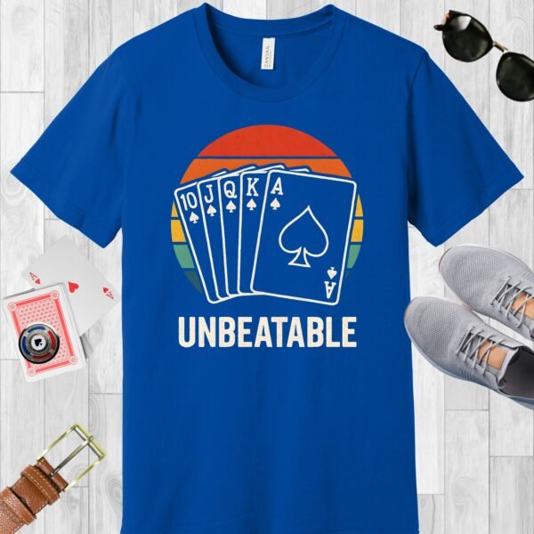 True Royal (blue) colored Bella+Canvas crewneck poker-themed T-shirt. Design features a vintage sunset overlaid with a royal flush, and the text 'Unbeatable'.