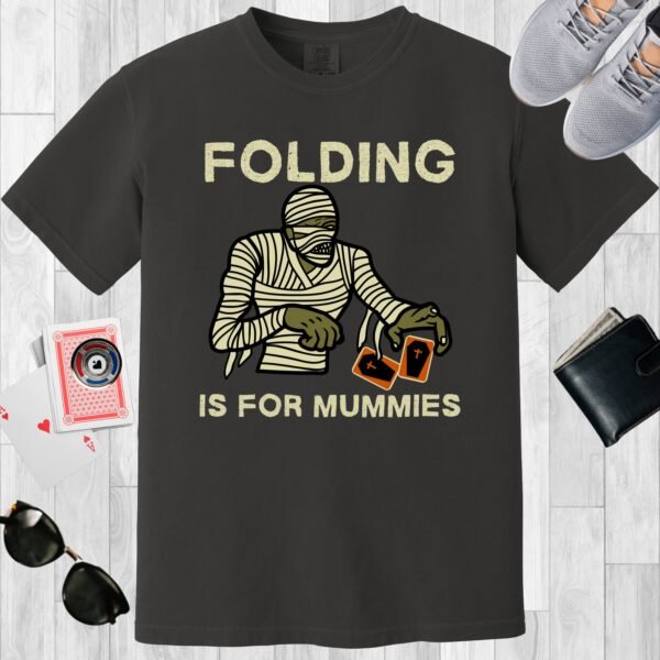 Graphite colored unisex crewneck poker-themed T-shirt. Design features the text 'Folding is for mummies'. A mummy folding a pair of cards.