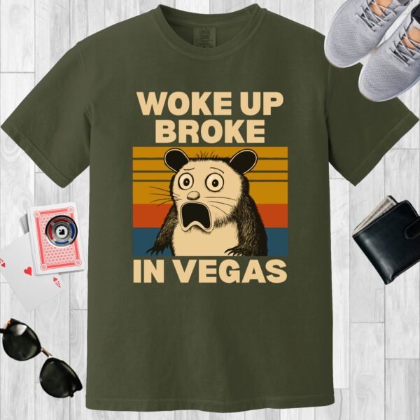 Moss colored unisex crewneck poker-themed T-shirt. Design features the text 'Woke up broke in Vegas'. Image of a stunned possum on a sunset background.