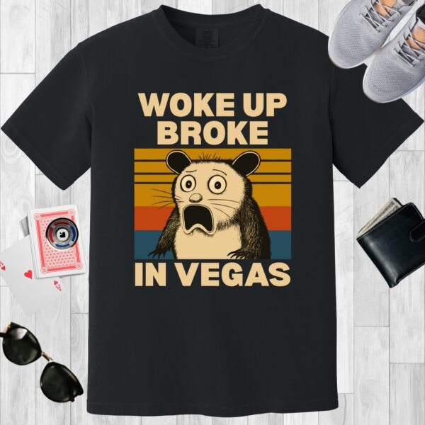 Black colored unisex crewneck poker-themed T-shirt. Design features the text 'Woke up broke in Vegas'. Image of a stunned possum on a sunset background.