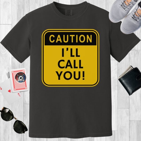 Graphite colored unisex crewneck poker-themed T-shirt. Design features the text 'Caution I'll call you' on a square yellow background.