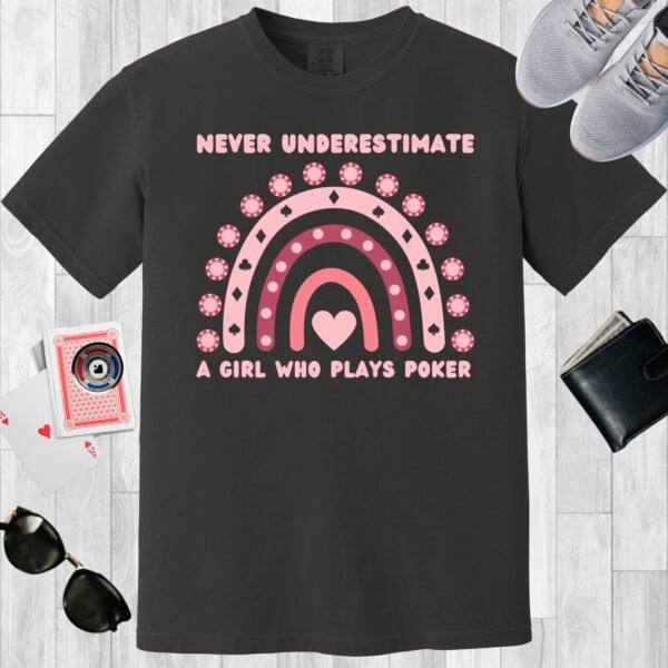 Graphite colored unisex crewneck poker-themed T-shirt. Design features the text Never underestimate a girl who plays poker'. Includes an image of a boho rainbow incorporating poker chips.