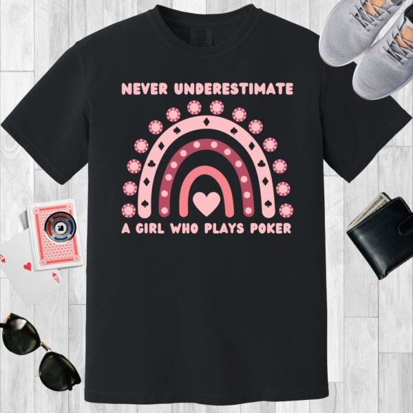 Black colored unisex crewneck poker-themed T-shirt. Design features the text Never underestimate a girl who plays poker'. Includes an image of a boho rainbow incorporating poker chips.