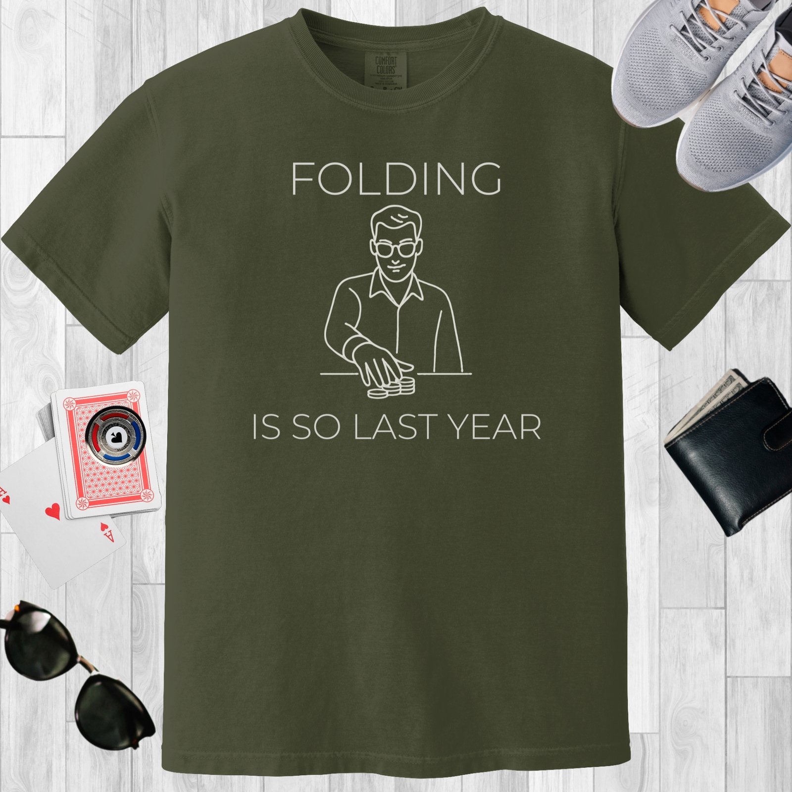 Moss colored unisex crewneck poker-themed T-shirt. Design features the text 'Folding is so last year'. Image is a minimalist line image of a man with stacks of poker chips.