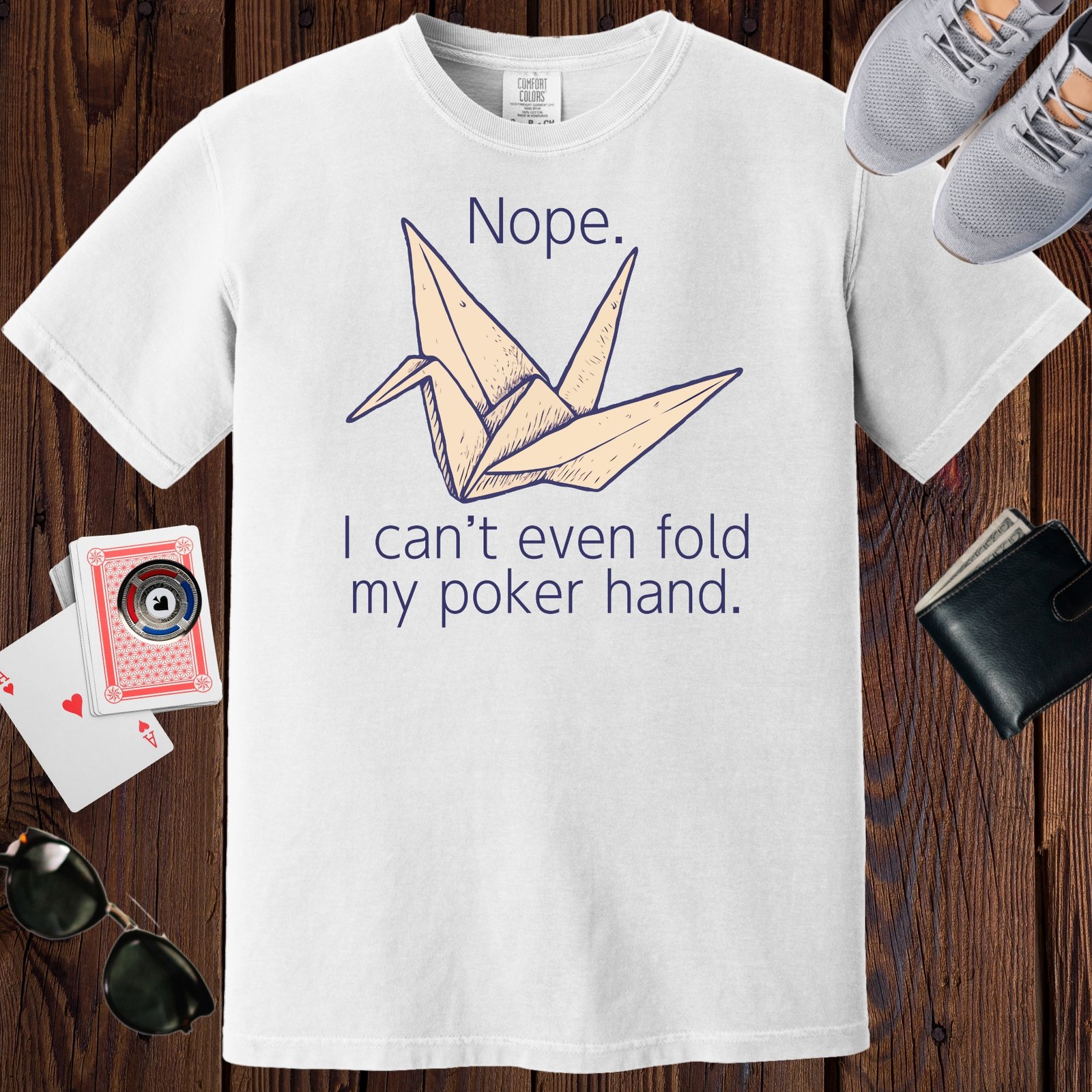 White colored unisex crewneck poker-themed T-shirt. Design features the text 'Nope. I can't even fold my poker hand.' An image of an origami paper crane.