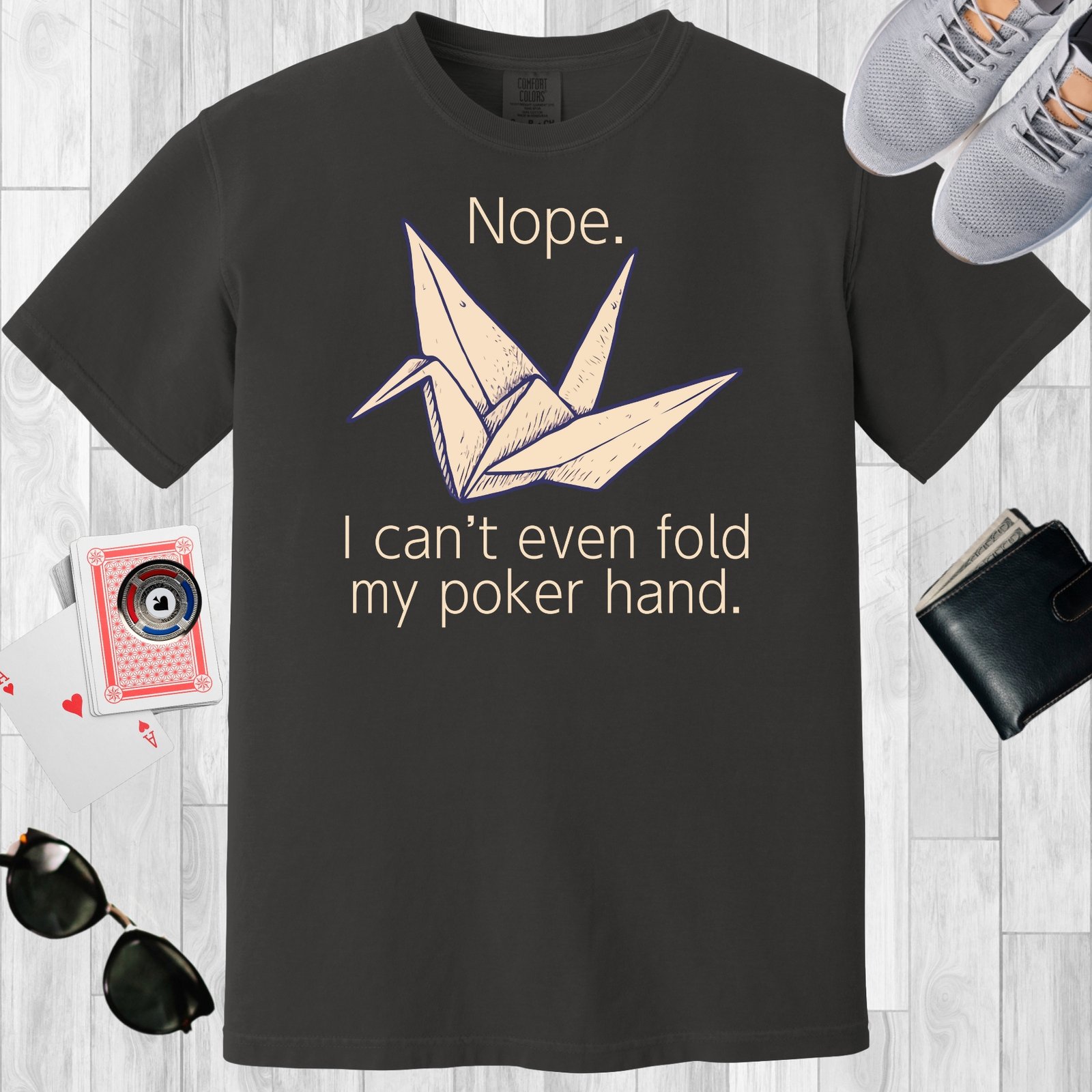 Graphite colored unisex crewneck poker-themed T-shirt. Design features the text 'Nope. I can't even fold my poker hand.' An image of an origami paper crane.