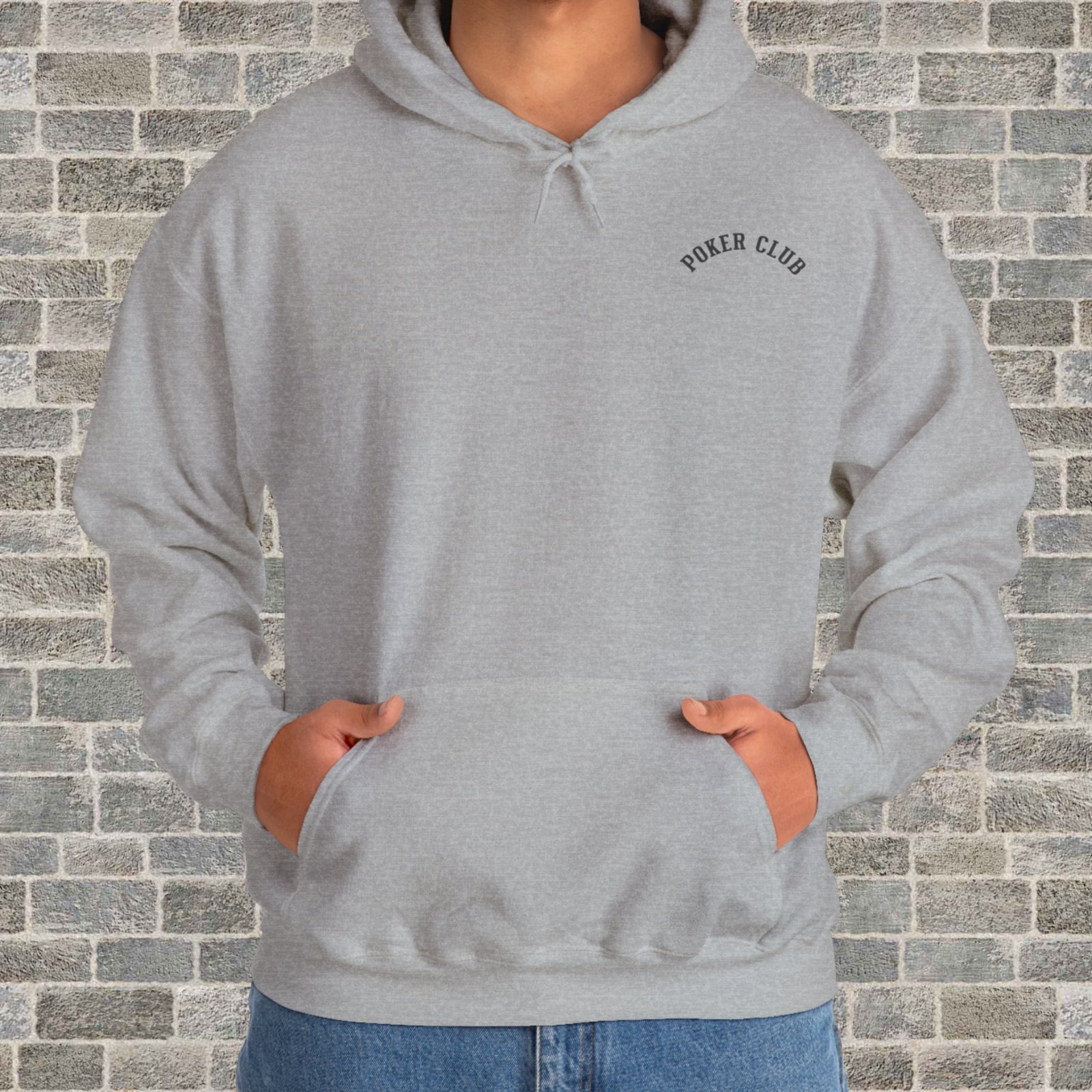 Person wearing a sport grey poker-themed Gildan hooded sweatshirt with the small left chest text "Poker Club" in front of a brick wall.