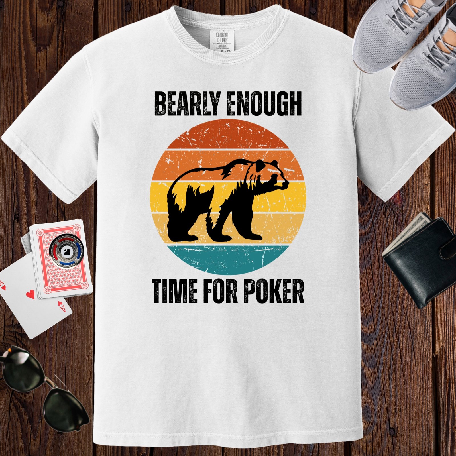 White colored unisex crewneck poker-themed T-shirt. Design features the text 'Bearly enough time for poker'. Image of a grizzly bear on a retro sunset background.