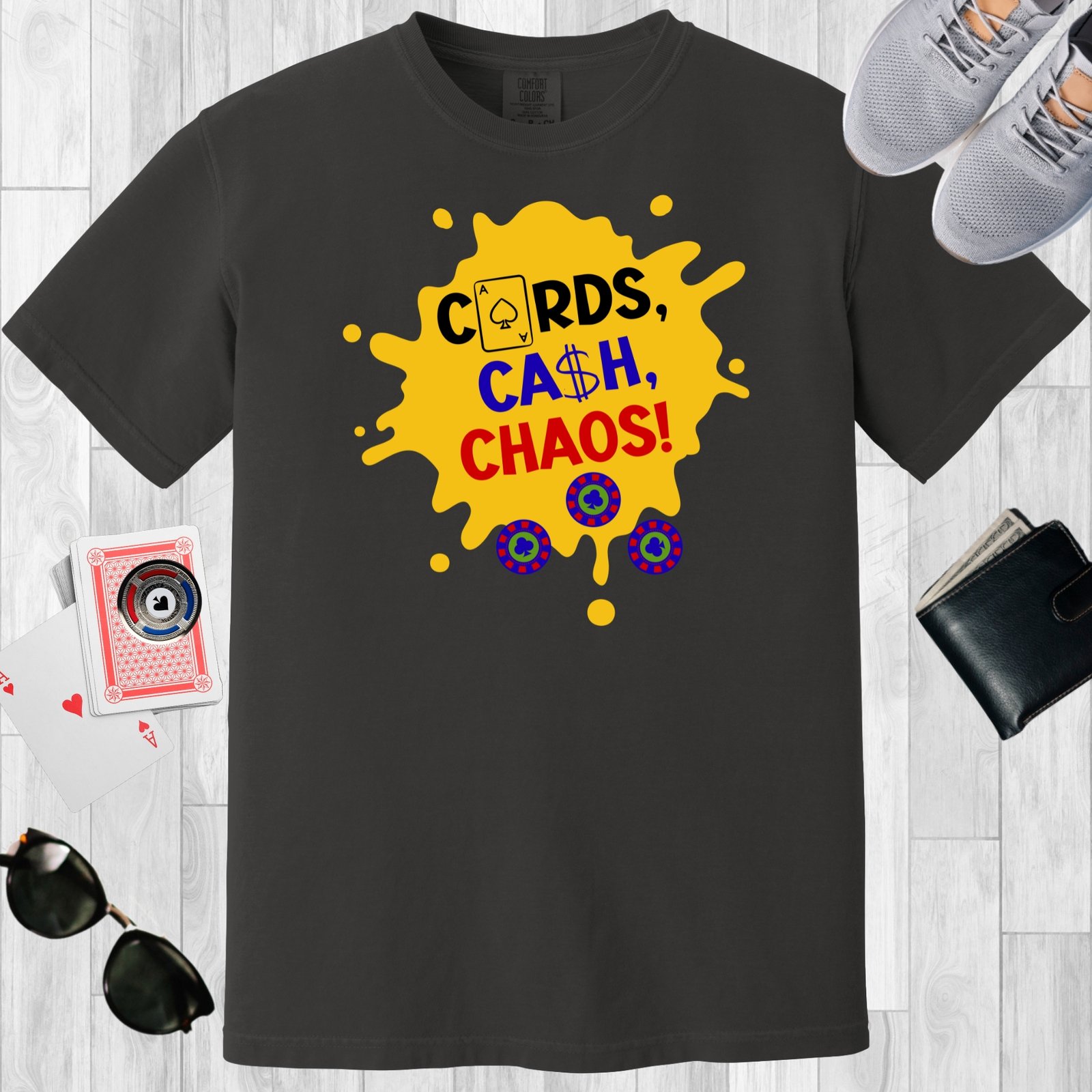 Graphite colored unisex crewneck poker-themed T-shirt. Design features the text 'Cards, Cash, Choas'. The text and a few poker chips are positioned over a yellow paint splotch.